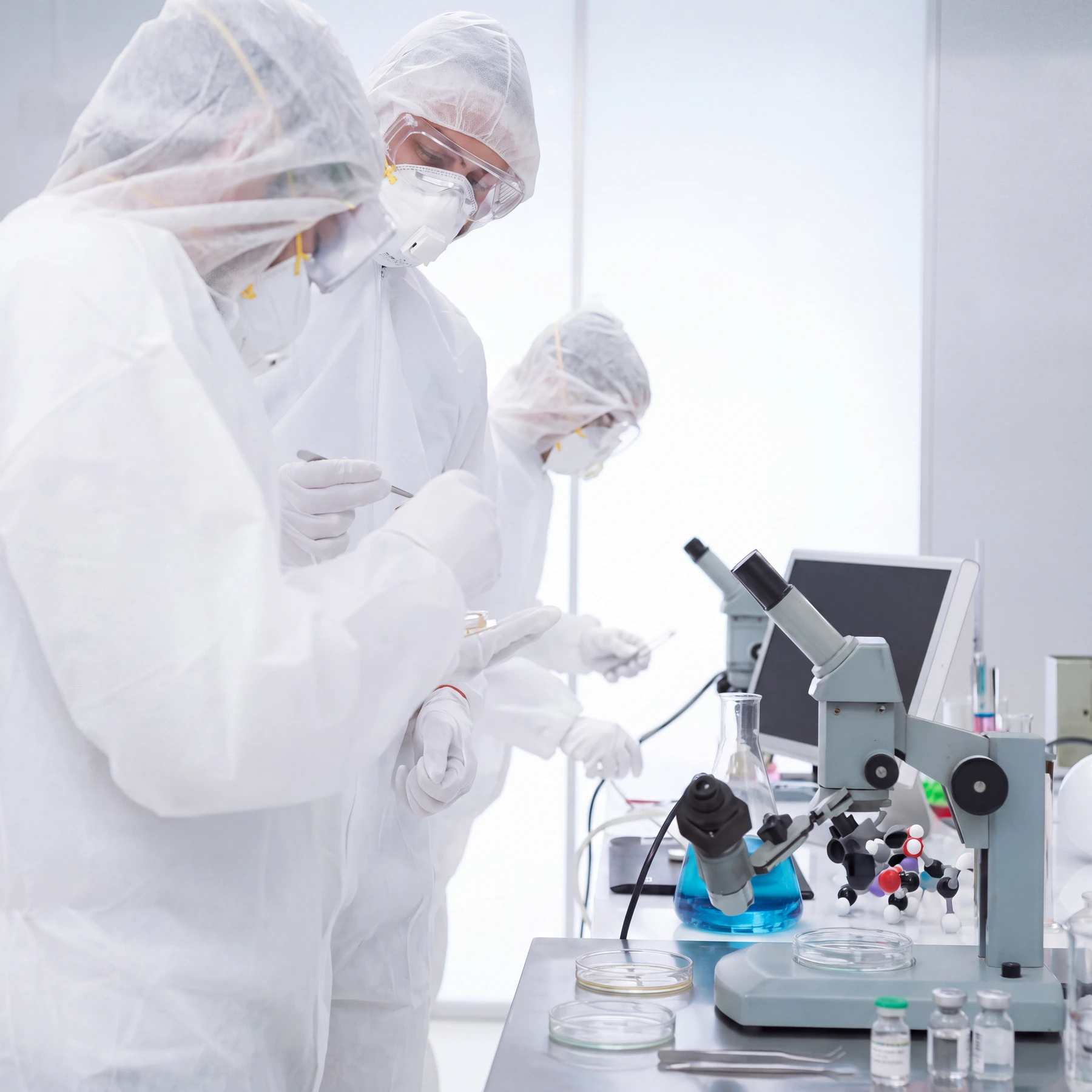 Laboratory researchers working with microscopes and testing equipment